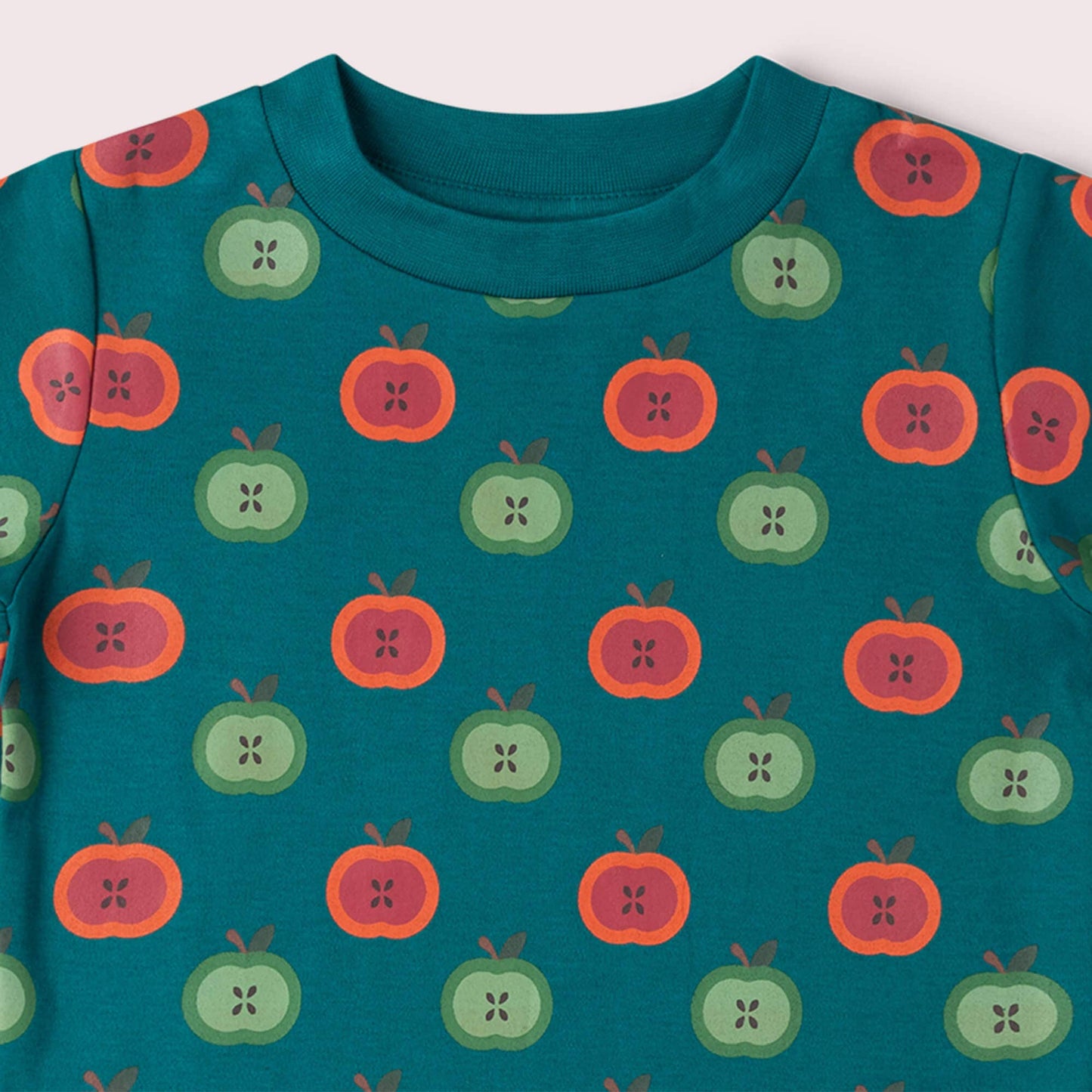 Teal shirt with apple pattern on a white background
