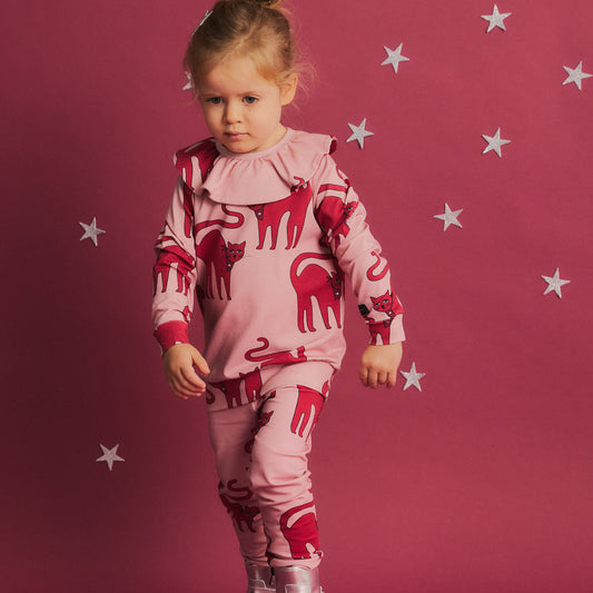 Girl wearing Dear Sophie organic Frill long sleeved top- cat pink