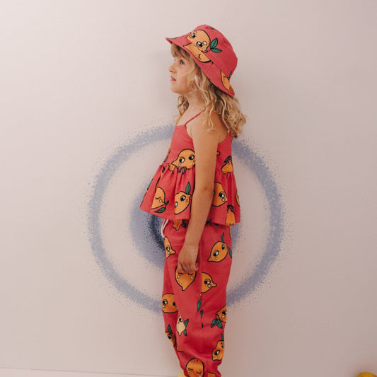 Girl wearing Dear Sophie organic Peplum tank top- lemon pink