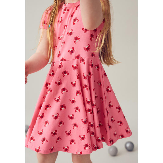 Girl wearing Fred's World organic Swing dress- pink crab