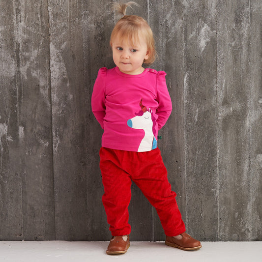 Girl wearing Fred's World organic Puff sleeve top- unicorn appliqué