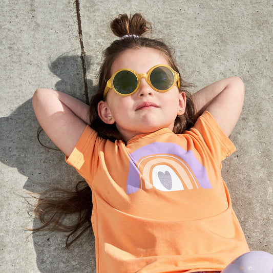 Girl wearing Fred's World organic Short sleeve top- rainbow heart