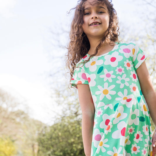 Girl wearing Frugi organic Skater dress- daisy field