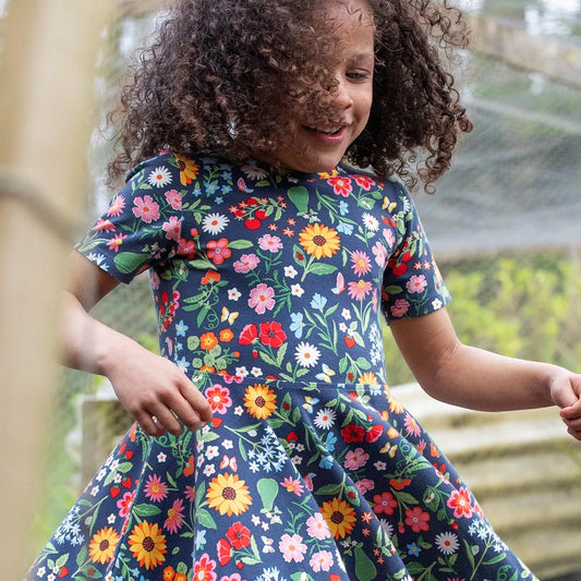 Girl wearing Frugi organic Skater dress- vegetable garden