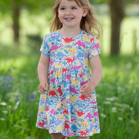 Girl wearing Kite organic Short sleeved dress- dinosaurs