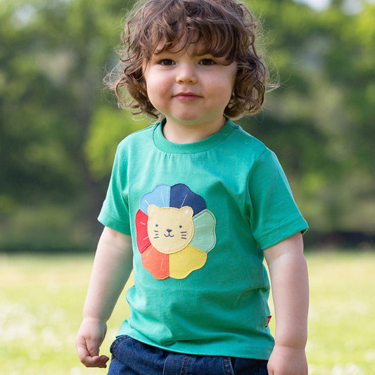 Boy wearing Kite organic T-shirt- rainbow lion appliqué