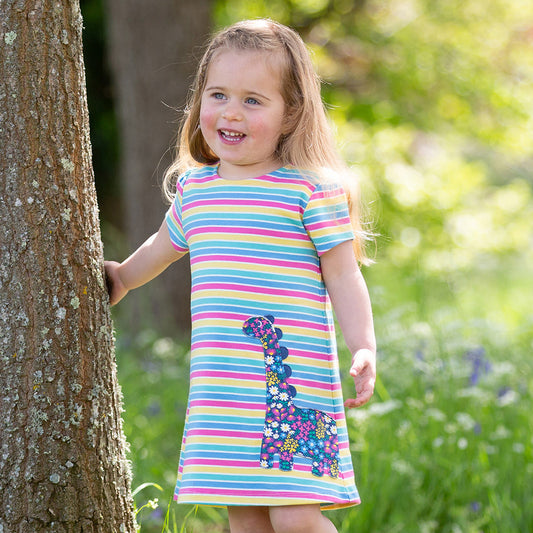 Girl wearing Kite organic Rainbow dinosaur appliqué dress