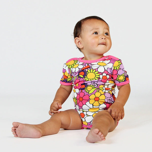 Baby wearing Smafolk organic Short sleeve bodysuit- flowers, spring pink