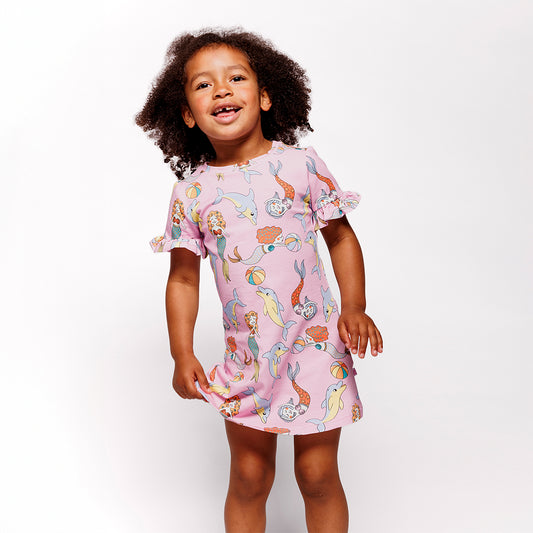 Girl wearing Smafolk organic Short sleeved dress- mermaids & dolphins, pink