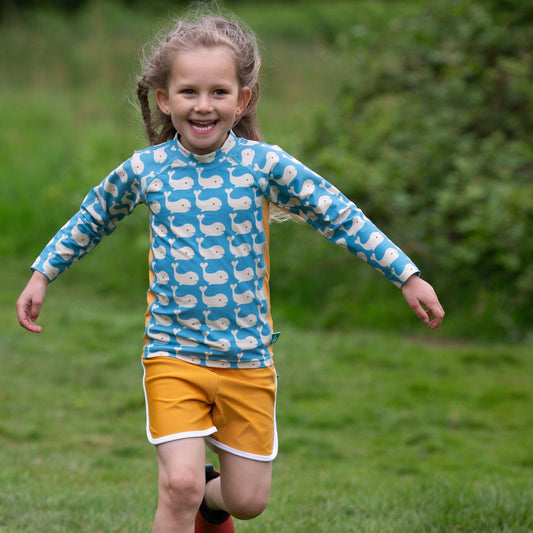 Girl wearing Little Green Radicals Recycled Rash guard- blue whales
