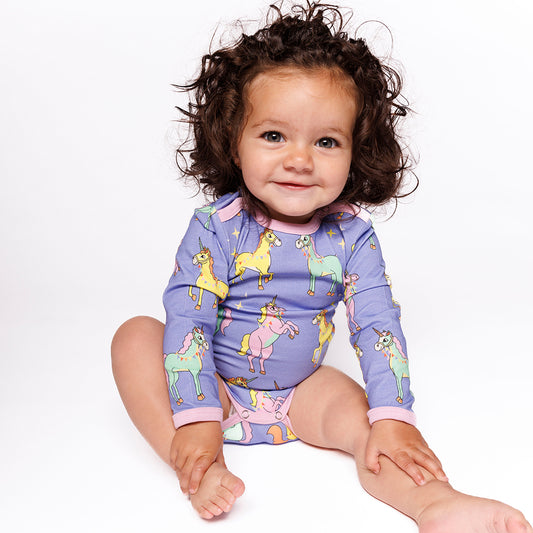Baby girl wearing Smafolk organic Long sleeved bodysuit- unicorn, purple