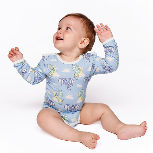 Baby wearing Smafolk organic Long sleeved bodysuit- sleeping dragons