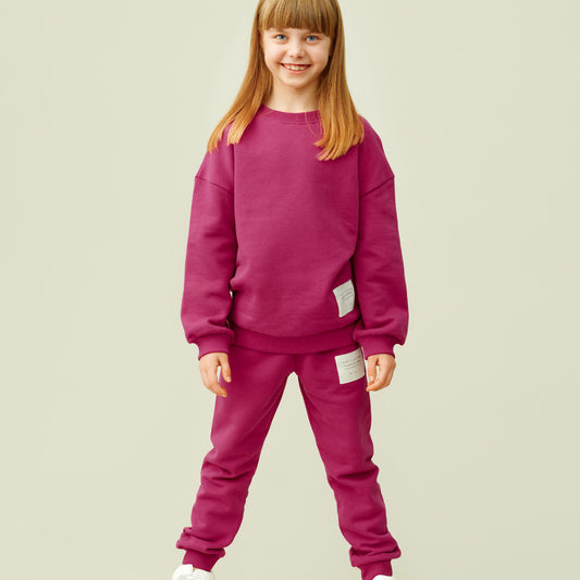 Girl wearing Mainio organic Superpower sweatshirt- fuchsia