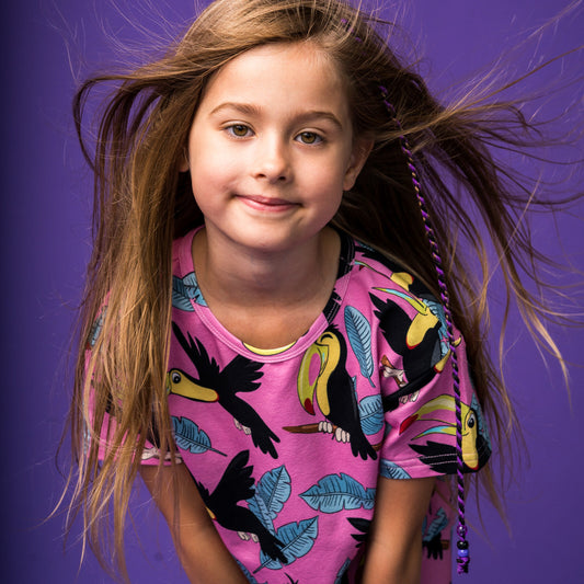 Girl wearing Mullido organic Crop top- pink toucan