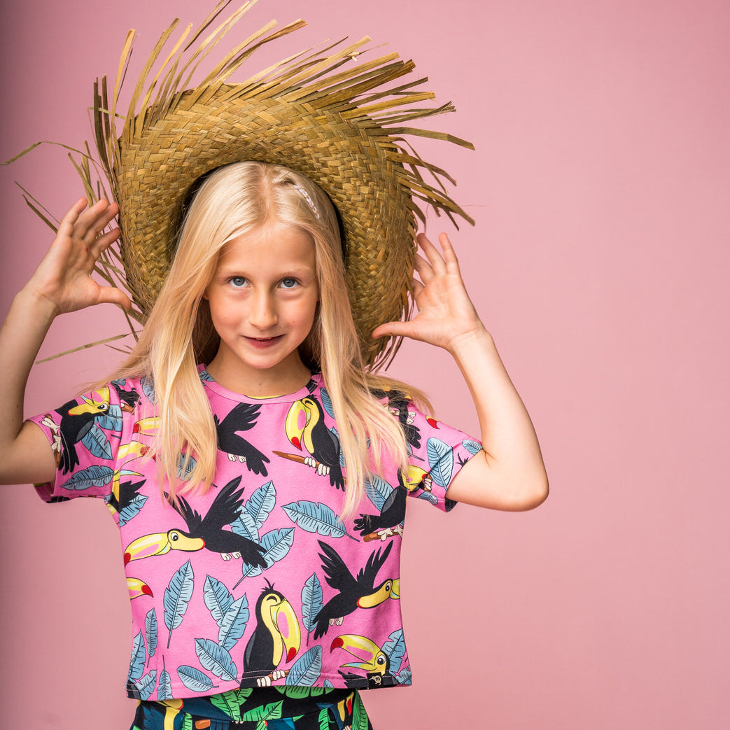 Girl wearing Mullido organic Crop top- pink toucan