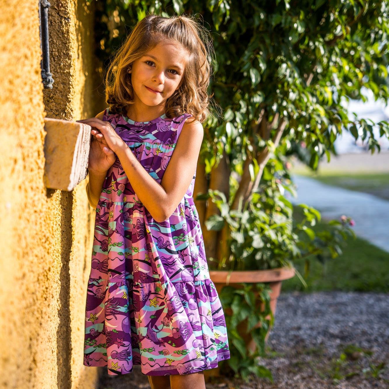 Girl wearing Mullido organic Sleeveless tiered dress- octopus, purple