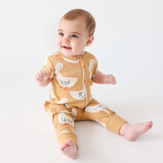 Baby wearing Parade Organics Zip romper- goose