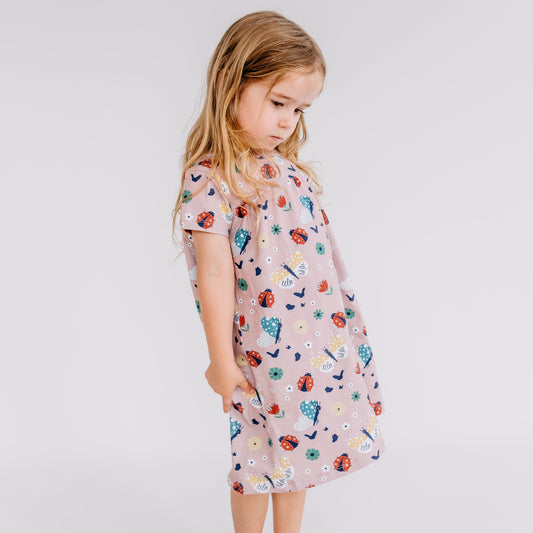 Girl wearing Walkiddy organic Short sleeve dress- ladybugs & butterflies
