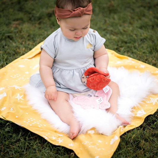 Baby with Tikiri Toys organic Crinkle toy- ladybug