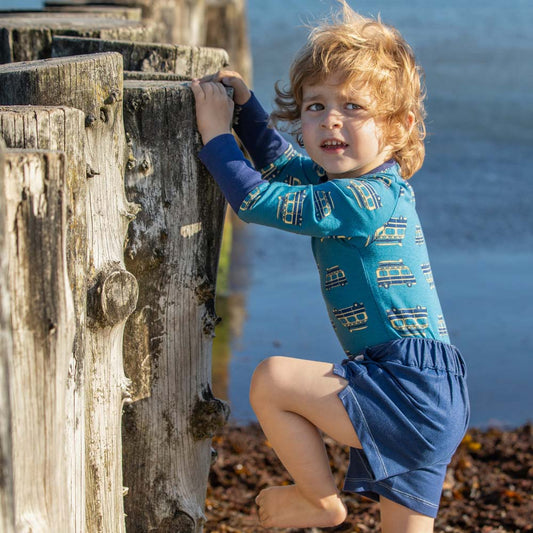Boy wearing Alba of Denmark Sunrise bodysuit- blue on the road