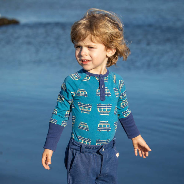Boy wearing Alba of Denmark Sunrise bodysuit- blue on the road