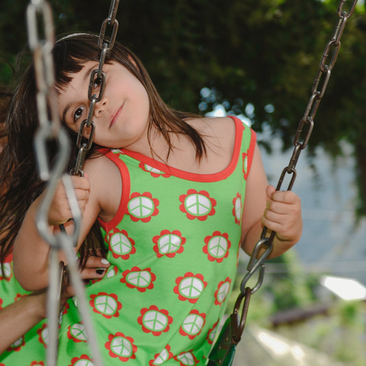 Girl wearing Moromini organic Tank dress with fringe- peace flower