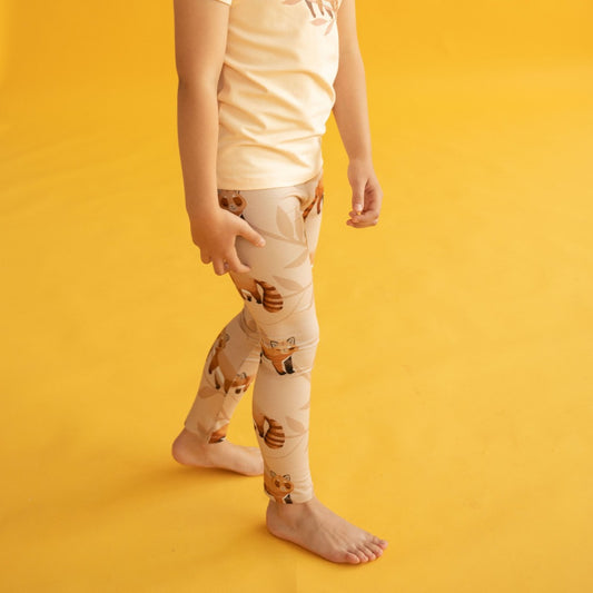 Girl wearing Curious Stories organic Leggings- cozy red panda
