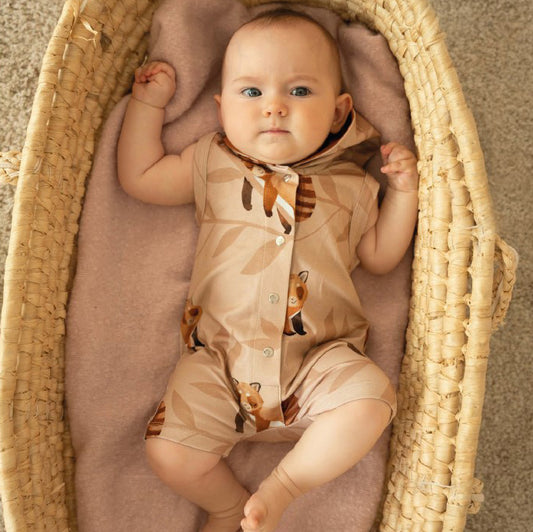 Baby wearing Curious Stories organic Romper- cozy red panda