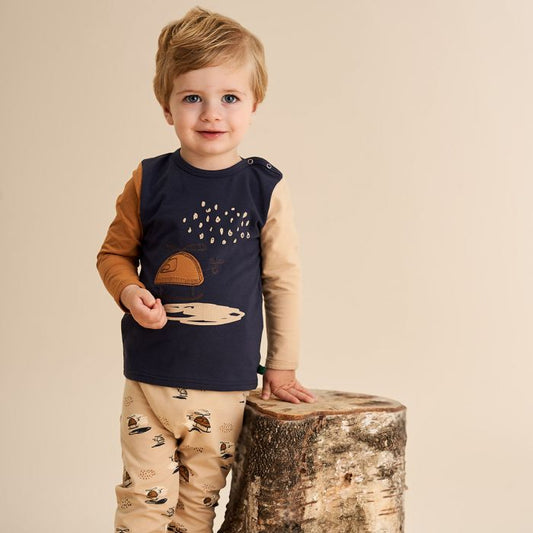 Baby wearing Fred's World organic Baby pants- helicopter print