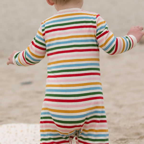 Baby wearing Little Green Radicals organic Rainbow striped footed pajamas