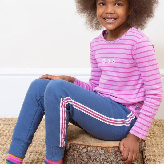 Girl wearing Kite organic Navy side stripe joggers