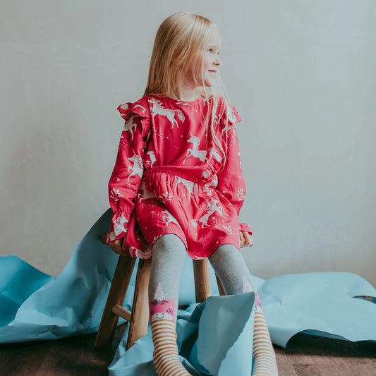 Girl wearing Lilly + Sid organic unicorn viscose dress