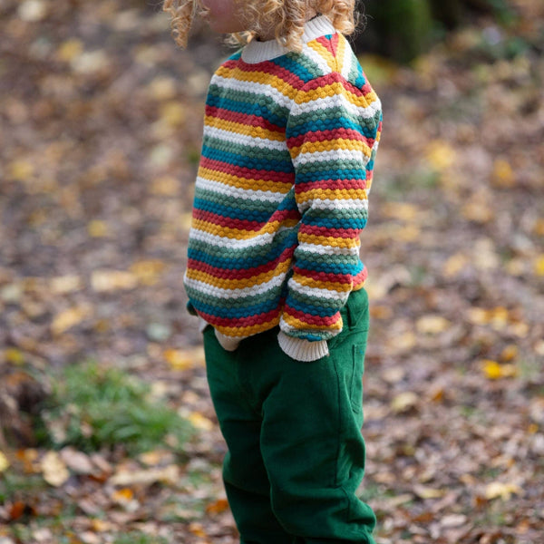 Boy wearing Little Green Radicals organic Knit sweater- honeycomb rainbow striped