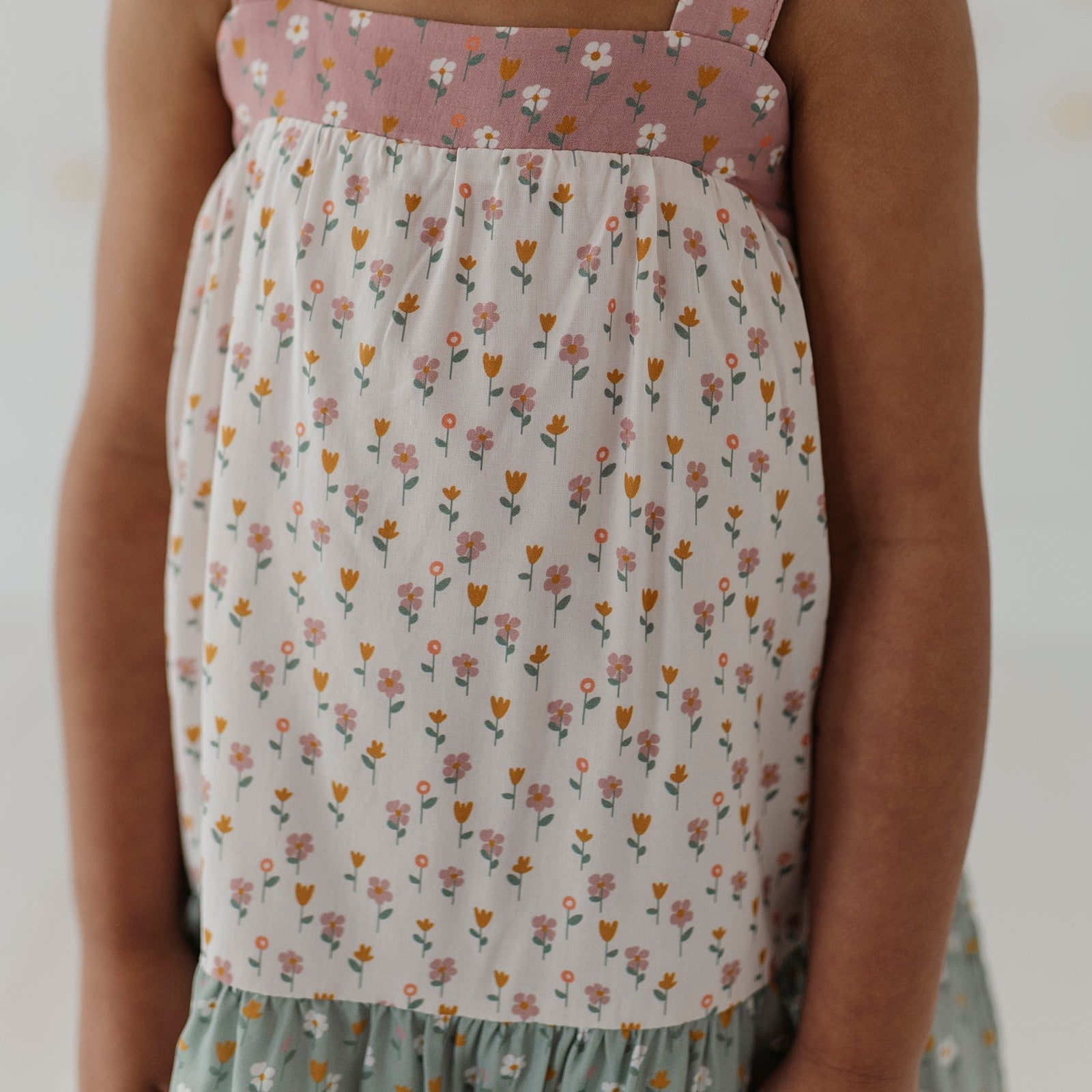 Child wearing a floral dress with a white background