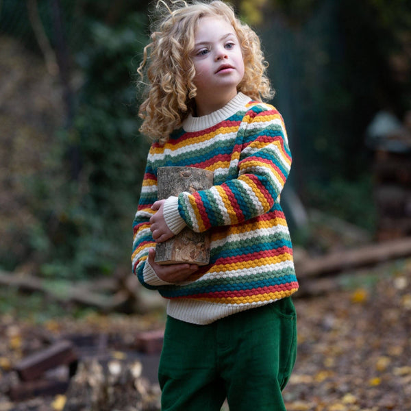 Boy wearing Little Green Radicals organic Knit sweater- honeycomb rainbow striped