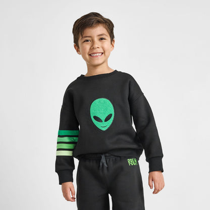 Child wearing a black sweatshirt with a green alien face design and matching pants on a light gray background