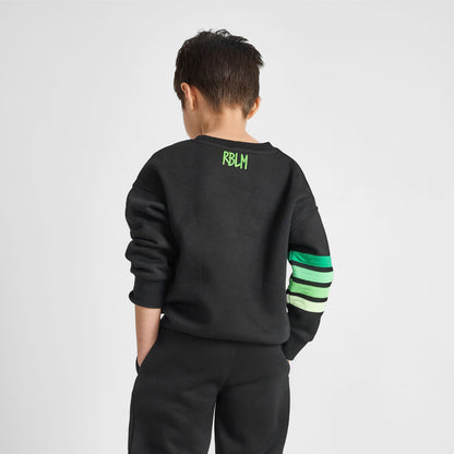 Child wearing a black tracksuit with green accents on a white background