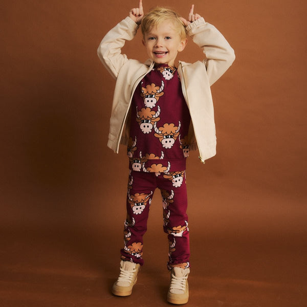 Boy wearing Dear Sophie organic Jogger pants- bull dark red