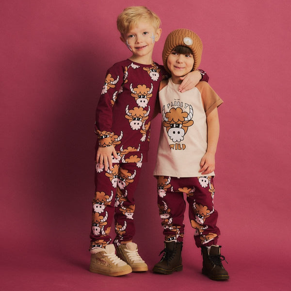 Boy wearing Dear Sophie organic Jogger pants- bull dark red