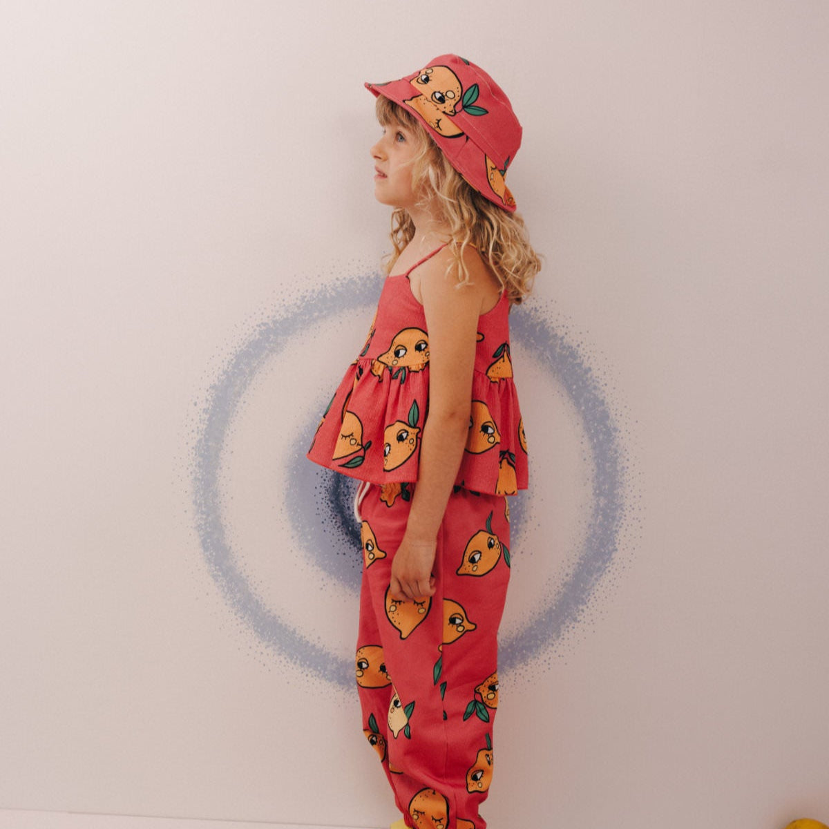 Girl wearing Dear Sophie organic Peplum tank top- lemon pink