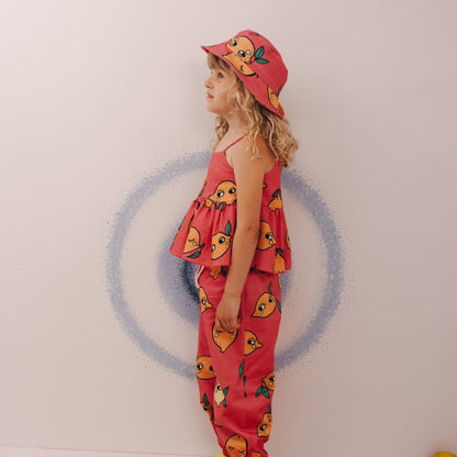 Girl wearing Dear Sophie organic Peplum tank top- lemon pink