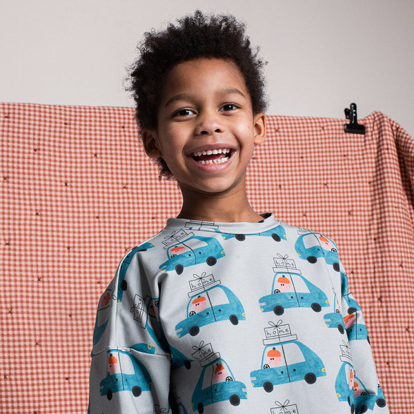 Boy wearing Don't Grow Up organic Sweatshirt- driving cars