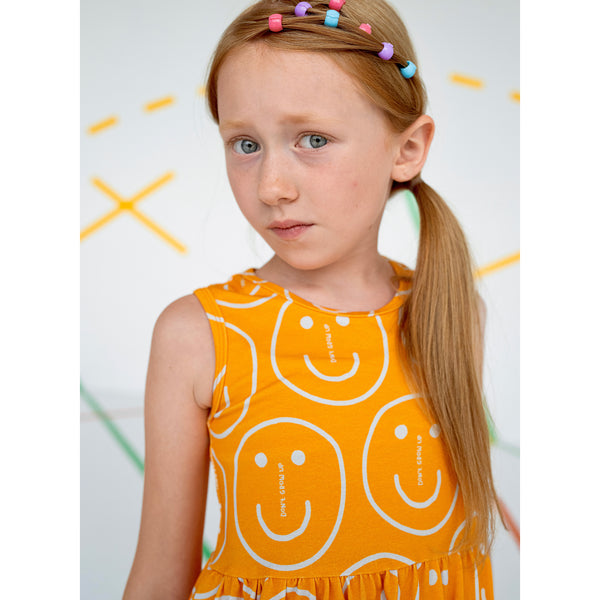 Girl wearing Don't Grow Up organic Tank dress- orange smiley