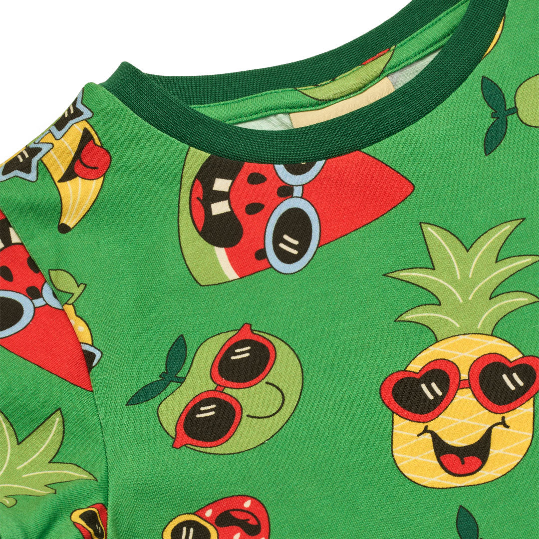 Close-up of a green fabric with colorful fruit patterns wearing sunglasses on a white background