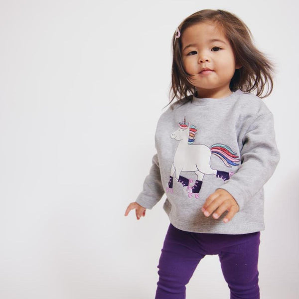 Girl wearing Fred's World Sweatshirt- unicorn appliqué