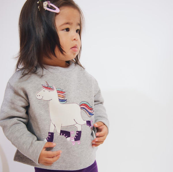 Girl wearing Fred's World Sweatshirt- unicorn appliqué