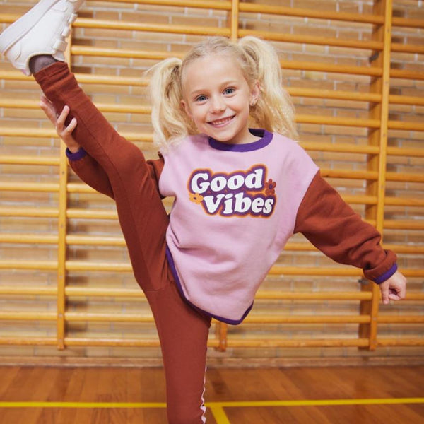 Girl wearing Fred's World organic Sweatshirt- good vibes colorblock