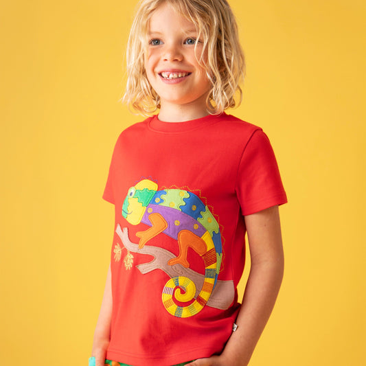 Child wearing a red t-shirt with a colorful chameleon design on a yellow background