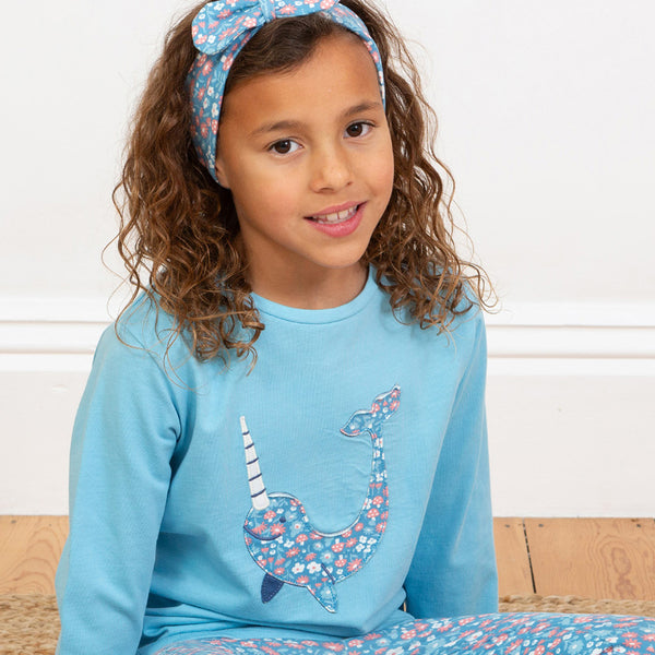 Girl wearing Kite organic T-shirt- narwhal appliqué