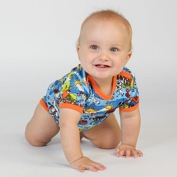Baby wearing Smafolk organic Short sleeve bodysuit- farm, brilliant blue